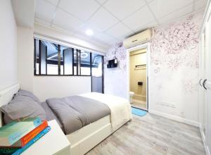a bedroom with a bed with books on a table at Pillows CoLiving in Hong Kong