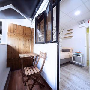 a room with a chair and a table and a bed at Pillows CoLiving in Hong Kong