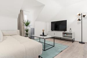 a white bedroom with a bed and a tv at PAKITO: Kassel Zentrum - Workstation - Stilvoll & Komfortabel in Kassel