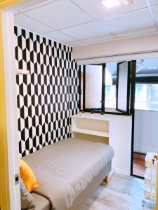 a bedroom with a black and white checkered wall at Pillows CoLiving in Hong Kong