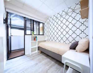 a small bedroom with a bed and a window at Pillows CoLiving in Hong Kong