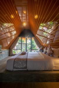 1 dormitorio con 1 cama grande y techo de madera en Mangoforest Bali, en Panji