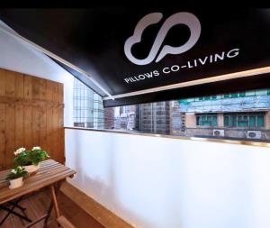 a sign for a windows coling store with a table at Pillows CoLiving in Hong Kong