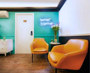a waiting room with two chairs and a sign that says better to poop at Pillows CoLiving in Hong Kong