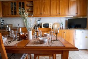 uma cozinha com uma mesa de madeira e copos de vinho em Panoramic View House em Tepelenë