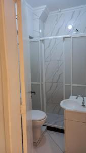 uma casa de banho com um chuveiro, um WC e um lavatório. em Apartamento inteiro com privacidade no Rio de Janeiro