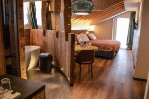 pokój hotelowy z łóżkiem i stołem z krzesłem w obiekcie Hotel Concordia w Livigno