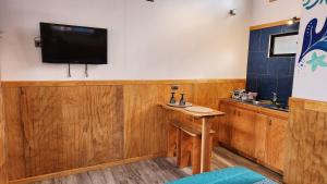 Una habitación con una mesa y un televisor en la pared. en HARE O HAUPIANO, en Hanga Roa