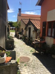 an alley with a house and a table and chairs at A Barraquinha 30 steps from sea in Apúlia