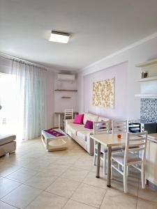 a living room with a couch and a table at Violet Sea View Apartment in Sarandë