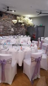 a room with white tables and chairs with purple bows at Royal Hotel in Forfar