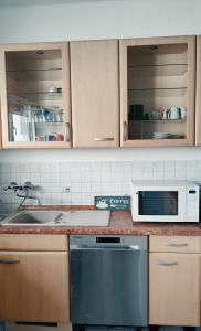 eine Küche mit einer Spüle und einer Mikrowelle in der Unterkunft Monteurwohnung 6 P. Mönchengladbach Rheydt in Mönchengladbach