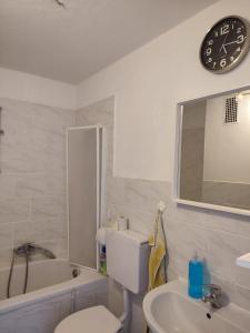 ein Badezimmer mit einem WC, einem Waschbecken und einer Uhr in der Unterkunft Monteurwohnung 6 P. Mönchengladbach Rheydt in Mönchengladbach