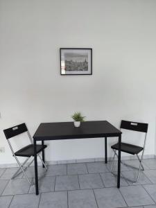 une table noire avec deux chaises et une plante sur elle dans l'établissement Monteurwohnung 6 P. Mönchengladbach Rheydt, à Mönchengladbach