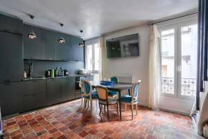 a kitchen with a table and chairs in a room at Splendide T2 à proximité du Parc Georges Brassens in Paris