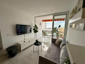 a living room with a couch and a balcony at Achacay View Apartment in Los Cristianos