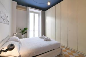 um quarto com uma cama com paredes brancas e uma janela em Primopiano - Giacosa em Milão