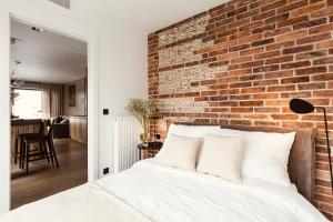 um quarto com uma parede de tijolos e uma cama em PANORAMA VIEW by Mint Apartment em Cracóvia