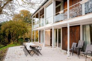 eine Terrasse mit Stühlen und einem Tisch vor einem Gebäude in der Unterkunft Villa Plesse - exklusiv und geräumig wohnen nahe Göttingen in Bovenden