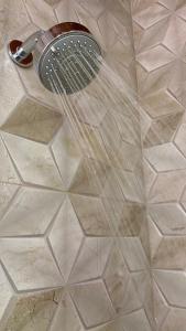 um chuveiro com uma ventoinha no piso de azulejo em Namata CHALÉS em Nova Friburgo