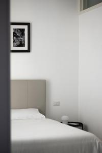 sypialnia z białym łóżkiem i obrazem na ścianie w obiekcie Rivin Apartment w Mediolanie