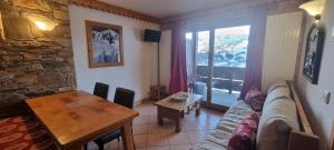 a living room with a couch and a table at travelski home premium - Résidence Les Hauts Bois in Aime La Plagne