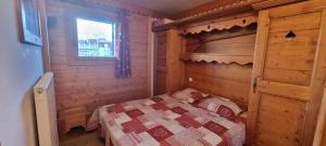 a bedroom with a bed in a wooden room at travelski home premium - Résidence Les Hauts Bois in Aime La Plagne