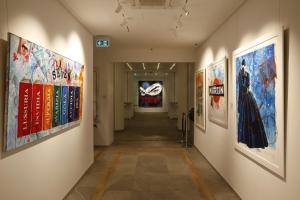 un corridoio con dipinti sulle pareti di un museo di Soul Art Hotel a Napoli