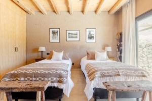 two beds in a room with a window at Rancho Adobe Eco Hotel in Tupungato