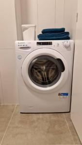 a white washing machine with a blue towel on top at Lovely apartment in City Center in Timişoara