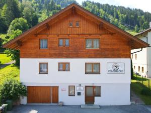 a large white building with a wooden roof at Vesterberg Apartments in Top Lage! Bike Garage Inklusive! in Schladming