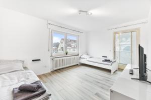 a white bedroom with a bed and a window at MONTEURWOHNUNG in Ebersbach EB02 RAUMSCHMIDE Apartments in Ebersbach an der Fils