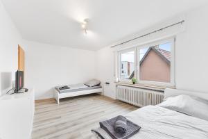 een witte slaapkamer met een bed en een raam bij MONTEURWOHNUNG in Ebersbach EB02 RAUMSCHMIDE Apartments in Ebersbach an der Fils