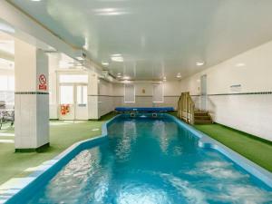 a swimming pool in a building with blue water at Craiglea Lodge in Latheron