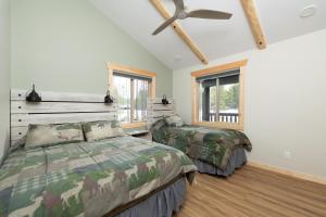 1 Schlafzimmer mit 2 Betten und einem Deckenventilator in der Unterkunft The Golden Eagle Cabin in Valemount