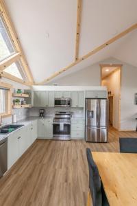 eine große Küche mit Küchengeräten aus Edelstahl und einem Tisch in der Unterkunft The Golden Eagle Cabin in Valemount