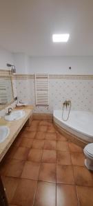 a bathroom with two sinks and a tub and a toilet at CASITA ROCIO in Jaén