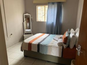 1 dormitorio con cama, ventana y espejo en Kappsfarm Guesthouse en Voigtland