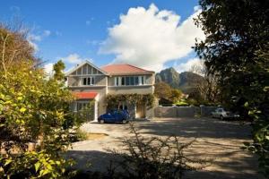 una casa con un coche aparcado en una entrada en Roodenburg House, en Ciudad del Cabo