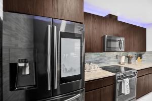 a kitchen with a stainless steel refrigerator and a stove at South Florida Splendor - Pool Home in Hollywood