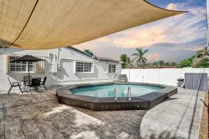 een patio met een zwembad en een huis bij South Florida Splendor - Pool Home in Hollywood