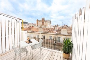 d'une table et de chaises blanches sur un balcon avec vue. dans l'établissement Les Appartements de Babel Vieux Port, à Marseille