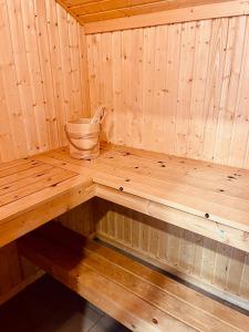 a wooden bench in a sauna with a bucket at Extertal-Ferienpark - Premium Ferienhaus Sauna Wandern #56a in Extertal