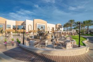 a resort with a fountain and chairs and palm trees at Sultan Gardens Resort in Sharm El Sheikh