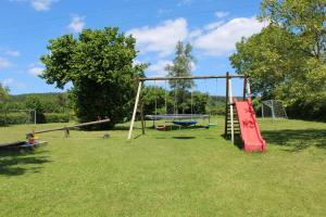 a park with a playground with a swing at La Gendarmerie in Chevron
