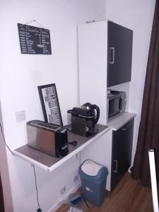 einen Schreibtisch mit einer Mikrowelle, einem Toaster und einer Mikrowelle in der Unterkunft un îlot de calme in Morlaix