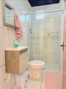 uma casa de banho com um chuveiro, um WC e um lavatório. em Chalés Sons do Mar em Barra do Cunhau