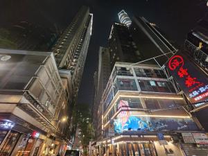 a busy city street at night with tall buildings at Pillows CoLiving in Hong Kong