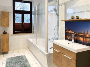 y baño con bañera, lavamanos y ducha. en FederTraum mit Sauna sehr gemütlich, NEU, en Dresden