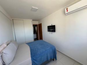 um quarto com uma cama e uma televisão na parede em Corais do Mar 204 Novo na Jatiúca em Maceió